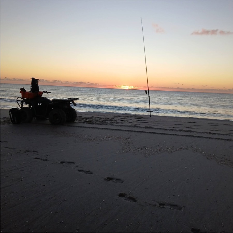 Quad bike and a rod set up on the beach at dusk